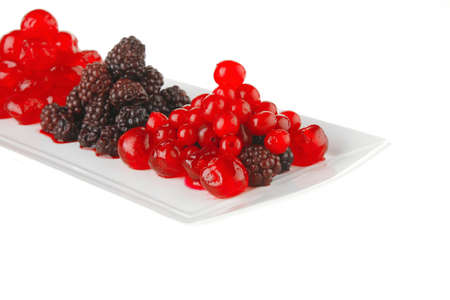 cherry and wild berrys over white dessert plateの写真素材