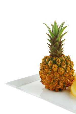 raw pineapple on white plate with slicesの写真素材