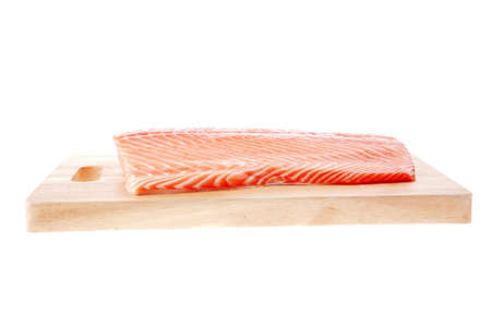 big salmon chunk on wooden plate over whiteの写真素材