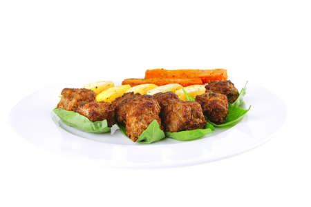 grilled meatballs on white plate with basil and potatoesの写真素材