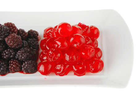 cherry and wild berrys over white dessert plateの写真素材