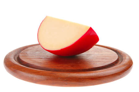 part of yellow cheese on dark wooden plate