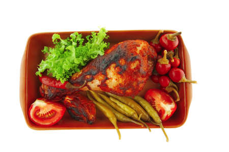 chicken drumstick with tomato and green peppers on whiteの写真素材