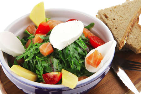 green salad with smoked salmon and bread on woodの写真素材