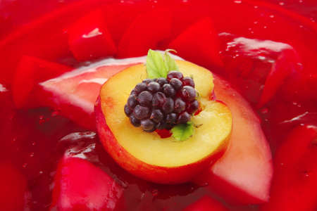sweet cold red jelly cake with fruits inside and blackberry