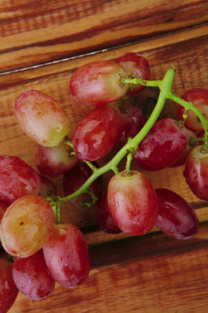 fresh raw red grape on wooden tableの写真素材
