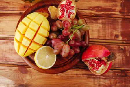 fresh raw fruits over red wooden plateの写真素材