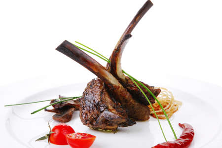 roast ribs with vegetables on white plate