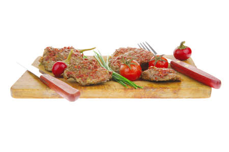 meat chops served with cutlery on wooden plateの写真素材