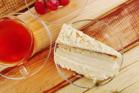 cream cake with tea and grapes on woodの写真素材