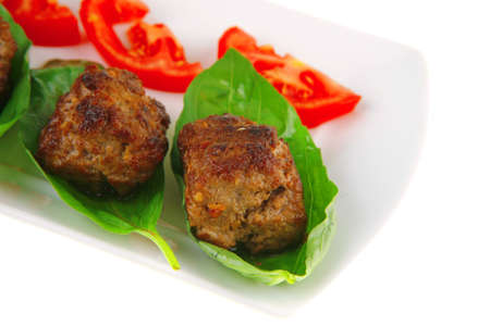 roasted beef cutlets on white with tomatoes and lemonの写真素材