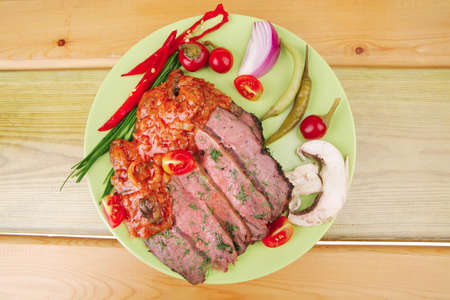 beef on plate with peppers over wooden tableの写真素材