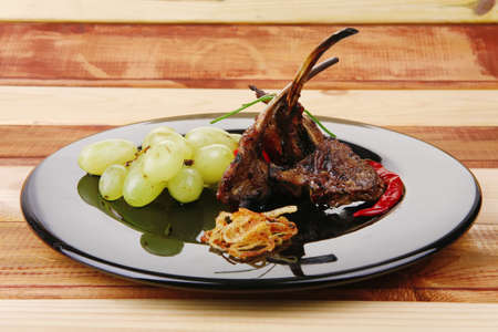 roast ribs on wooden table with grapesの写真素材