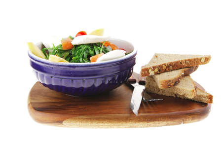 green salad with smoked salmon and bread on woodの写真素材