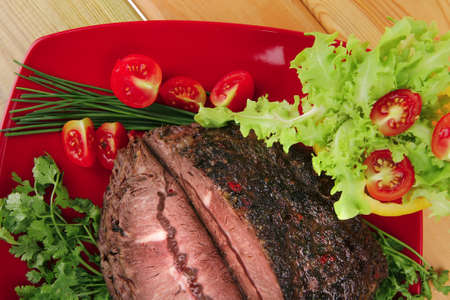 grilled beef sliced on red plate over woodの写真素材