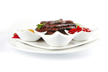 served meat and dishware on white dishの写真素材