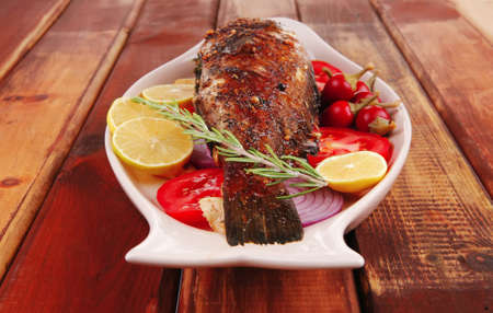 savory: whole fryed sunfish over wood with tomatoes lemons and peppersの写真素材