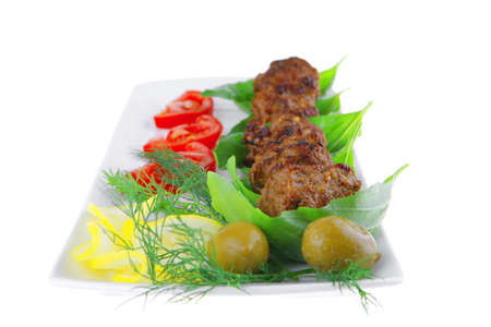 beef meat cutlet with tomatoes on long white plateの写真素材