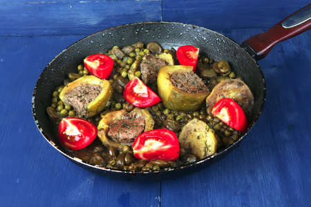 homemade cuisine: zucchini filled meat cooked with peas, beans, and tomatoes on panの写真素材