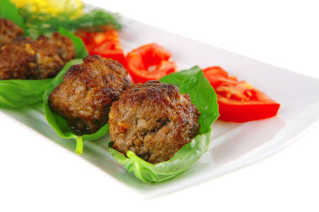 beef meat cutlet with tomatoes on long white plateの写真素材
