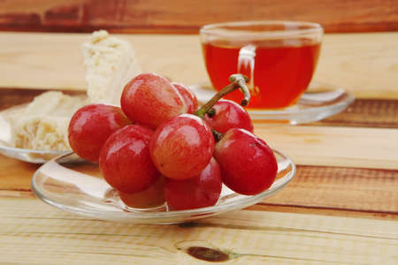 cream cake with tea and grapes on woodの写真素材