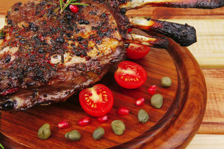 served ribs with cutlery on wooden tableの写真素材