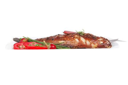 savory isolated on white: whole fryed sunfish over plate with tomatoes lemons and peppers