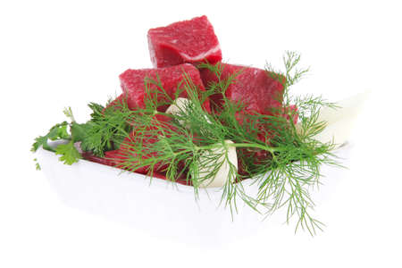 slices of raw fresh beef meat fillet in a white bowls with dill and green peppers isolated over white backgroundの写真素材