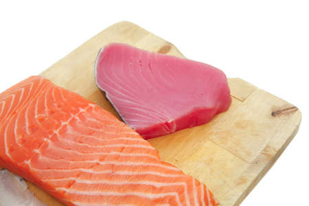 sea fish food : uncooked fresh sole , salmon , and red tuna fish pieces served over wooden board isolated on white backgroundの写真素材