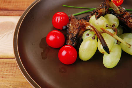meat ribs on dish with tomatoes on tableの写真素材
