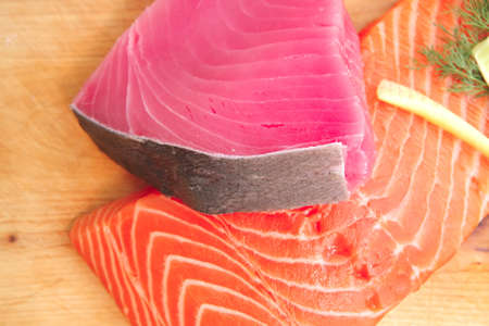 fresh raw salmon and tuna fish  pieces on wooden plate isolated on white background . shallow dofの写真素材