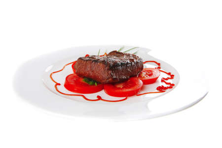 roasted meat served with tomato on ceramic plateの写真素材