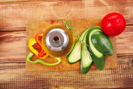 uncooked vegetables with olive oil over wooden tableの写真素材