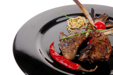 served ribs on plate with raw vegetablesの写真素材