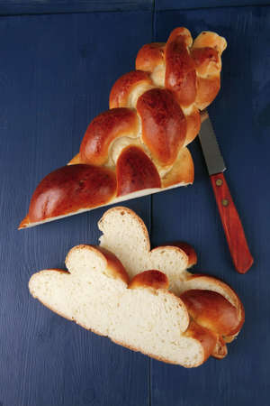 sweet bread : golden challah cuts over blue wooden plateの写真素材