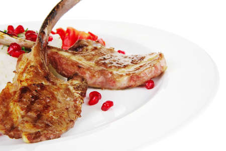 meat food: ribs on white plate with rice garnich and tomatoes over white backgroundの写真素材