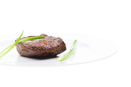 meat savory : grilled beef fillet mignon on white plate with green onion sprouts isolated over white backgroundの写真素材