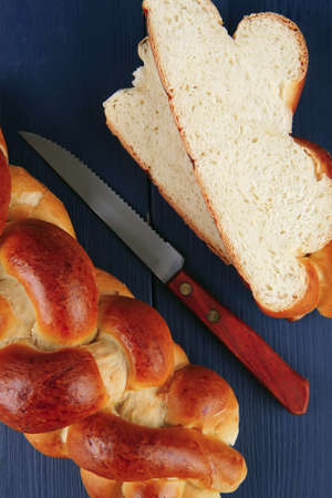 sweet bread : golden challah cuts over blue wooden plateの写真素材