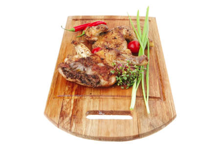 meat : grilled quarter chicken garnished with green sprouts and red peppers on wooden plate isolated over white backgroundの写真素材