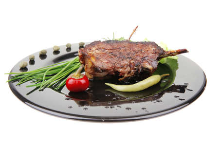 savory plate: grilled ribs over black with peppers and green saladの写真素材