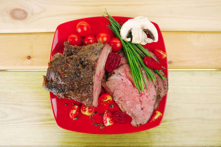 hot ham served on red dish over wooden tableの写真素材