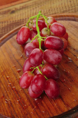 fresh raw red grape on wooden tableの写真素材