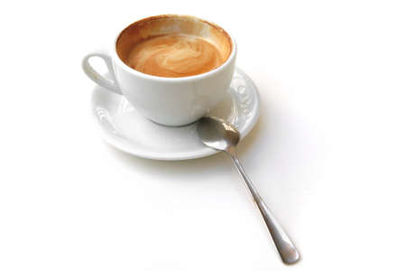 sweet drink : small white cup of cappuccino coffee on light background with spoonの写真素材
