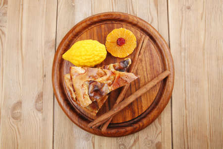 sweet apple cake on wooden table with lemon and cinnamon sticksの写真素材