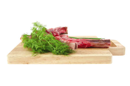 raw meat : boned fresh ribs served with dill and green chives on wooden board isolated over white backgroundの写真素材