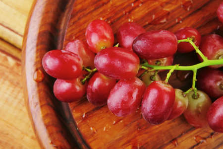 fresh raw red grape on wooden tableの写真素材