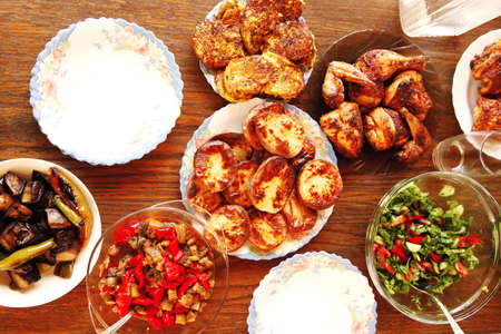 homemade food: salads and grilled chicked served over wooden tablesの写真素材