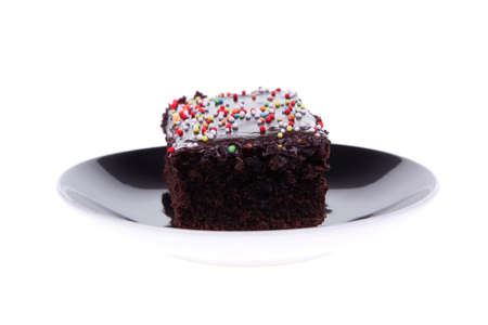 dessert : chocolate cake coated with chocolate on black saucer isolated over white backgroundの写真素材