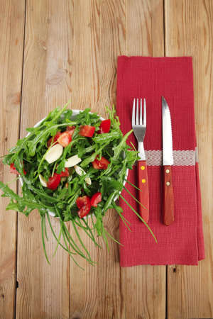 vegetable salad : green salad with raw tomato and garlic in white bowl over wood served with cutleryの写真素材