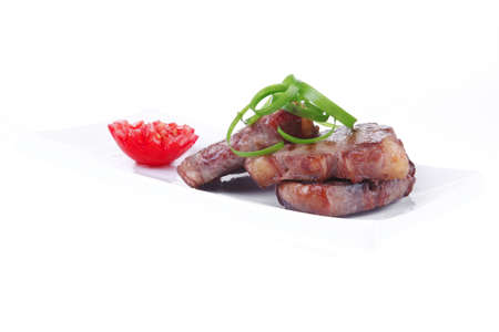 roasted beef meat strips on white ceramic plate isolated over white background